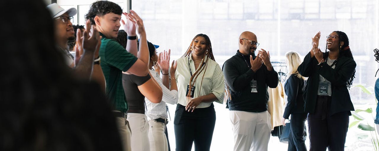 Participants clapping and laughing during an exercise.