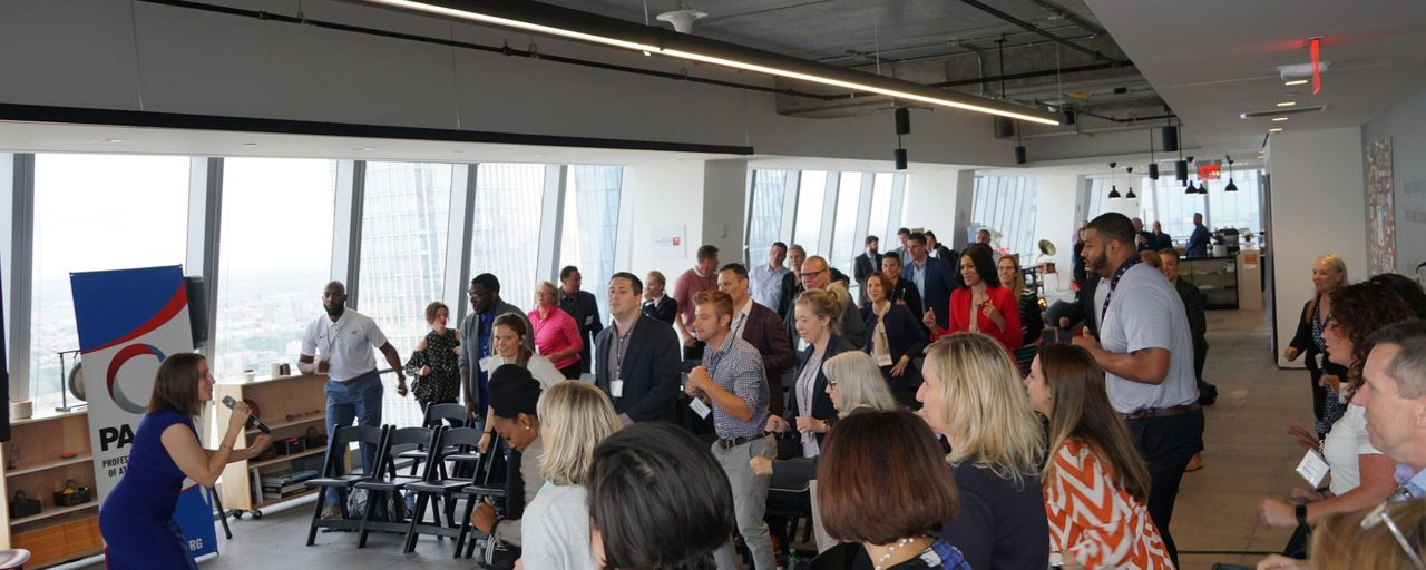 Conference attendees standing and moving during a session.
