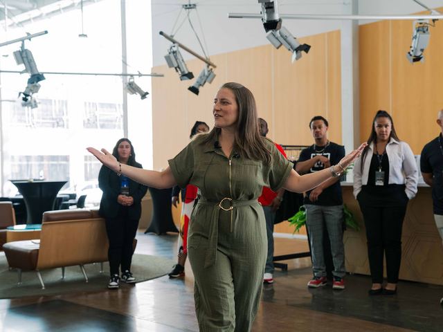 Lainie Hodges running an exercise with a standing group in an office.