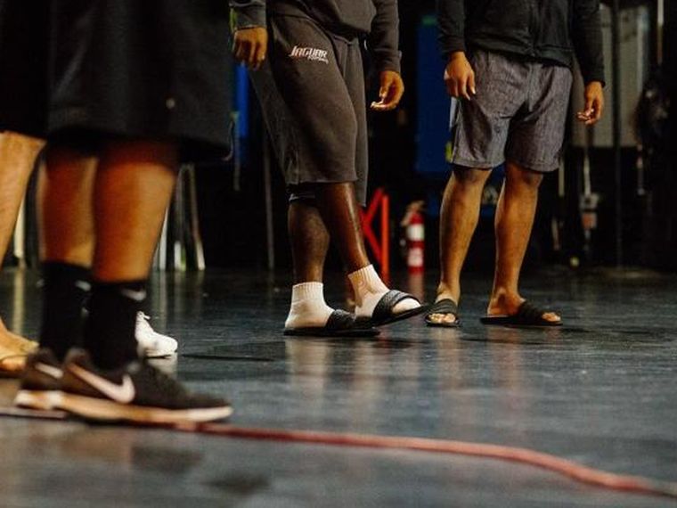 Players standing in a circle on a stage during a session exercise.